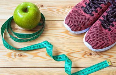 Spor ayakkabı, santimetre ve taze elma üst görüntüleyin. Sağlıklı ve activ