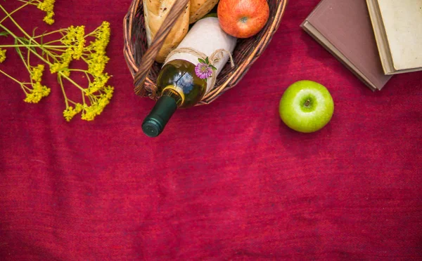 Корзина для пикника на красном одеяле вид сверху. яблоки, белое вино, б — стоковое фото