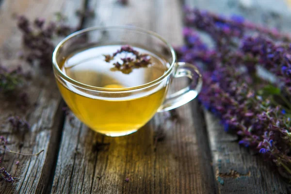 Bitkiler ile yeşil çay. Ahşap adam üzerinde kekik çayı