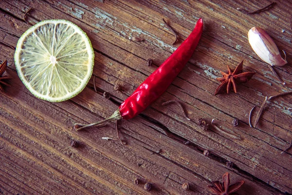 Röd chilipeppar, skiva lime och andra kryddor på en trä ba — Stockfoto
