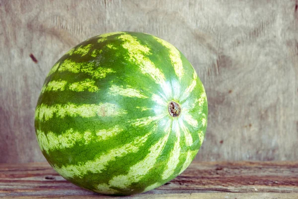 Ahşap arka plan üzerinde bütün karpuz
