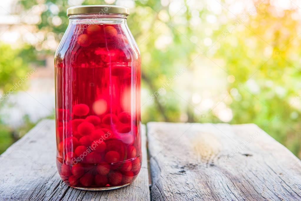 Cherry compote in the big glass jar. Homemade preserved cherries