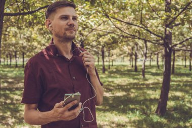 Yaz Park cep telefonu olan bir adam. Sm ile yakışıklı delikanlı