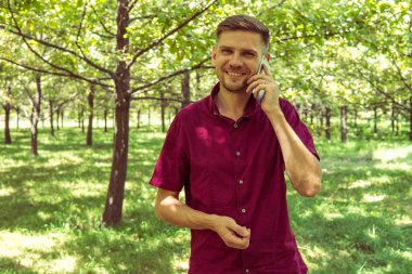 Yaz Park cep telefonu olan bir adam. Sm ile yakışıklı delikanlı