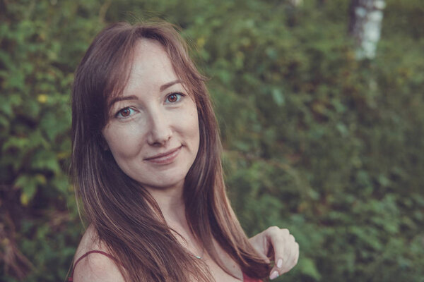 Young woman portrait in a summer forest in the mountains. Pretty