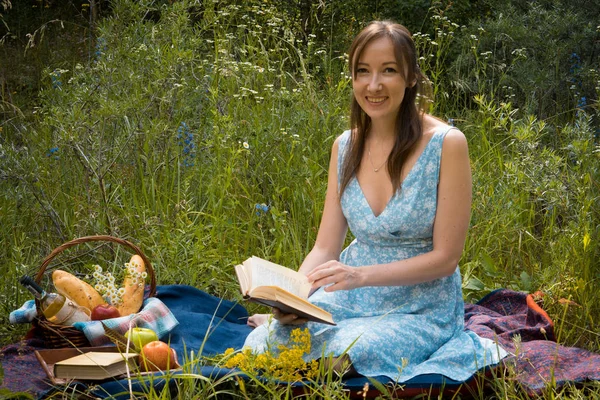 Picnic in nature at summer. Young woman in romantic blue dress i — Stock Photo, Image