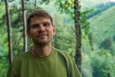 Genç adam portre dağlarda yaz ormandaki