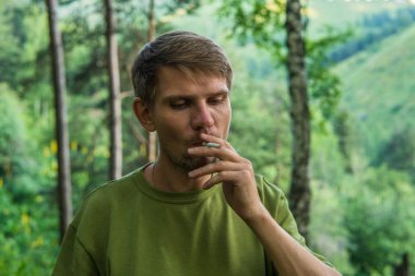 Sigara içmeyi mounta yaz ormanında genç adamdır