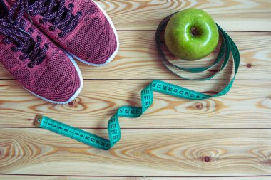 Spor ayakkabı, santimetre ve taze elma üst görüntüleyin. Sağlıklı ve activ