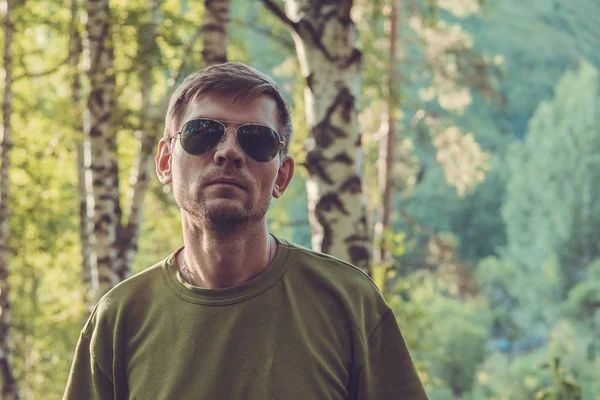 Stilvoller junger Mann im Sommerwald in den Bergen bei Almaty — Stockfoto