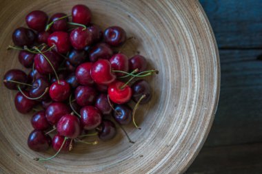 Rustik tarzı ahşap bir tabak içinde kiraz