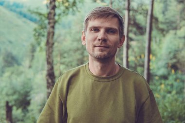 Genç adam portre dağlarda yaz ormandaki