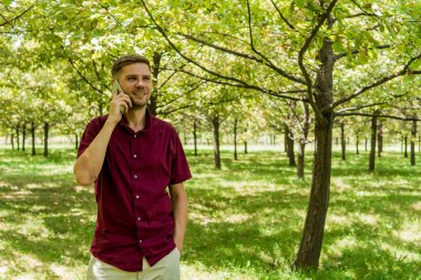 Yaz Park cep telefonu olan bir adam. Sm ile yakışıklı delikanlı