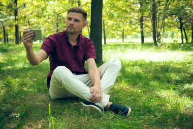 Genç adam yaz p selfie fotoğraf ile smartphone alıyor