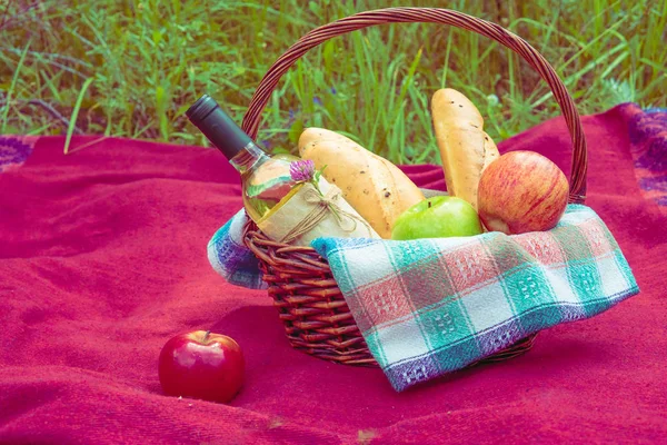 Doğa, kırmızı paket üzerinde piknik sepeti. Elma, beyaz şarap bir