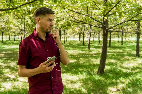 Yaz Park cep telefonu olan bir adam. Sm ile yakışıklı delikanlı