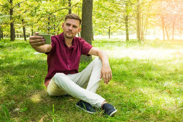 Genç adam yaz p selfie fotoğraf ile smartphone alıyor