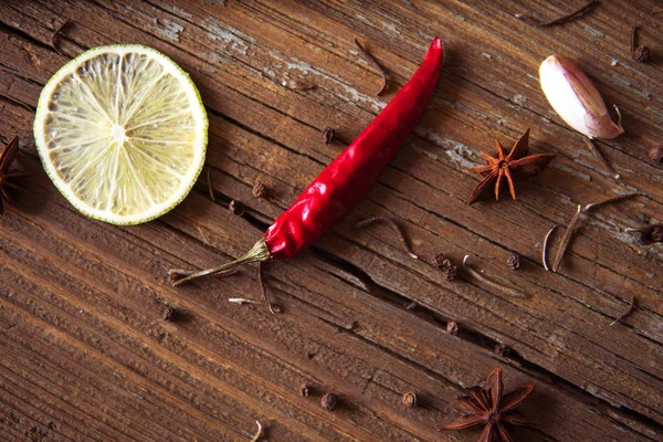 Κόκκινη καυτερή πιπεριά, φέτα lime και άλλα μπαχαρικά σε ξύλινα ΒΑ — Φωτογραφία Αρχείου