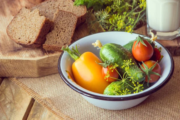 Bread, milk and vegetables on a wooden background in rustic styl