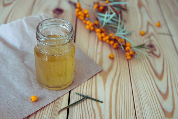 Honey in a glass jar and a branch of sea-buckthorn — Stock Photo, Image