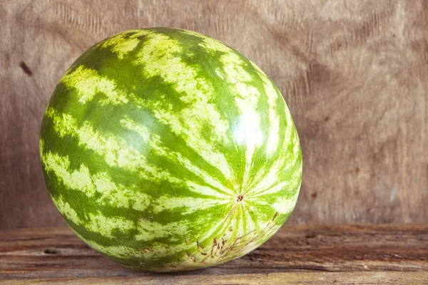 Ahşap arka plan üzerinde bütün karpuz