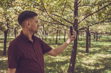 Yaz Park cep telefonu olan bir adam. Sm ile yakışıklı delikanlı