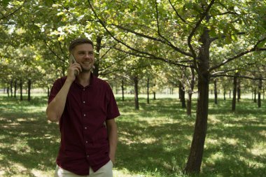 Yaz Park cep telefonu olan bir adam. Sm ile yakışıklı delikanlı