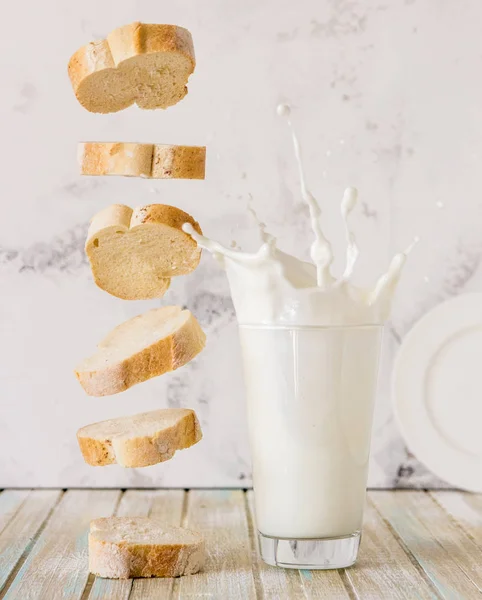 Chléb a mléko. Létající úvodní bagetu a mléka ve skle — Stock fotografie