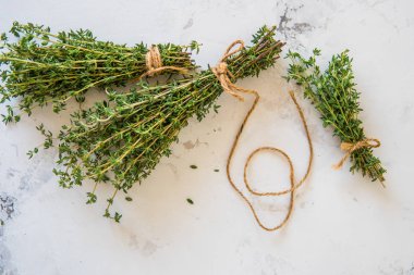 Beyaz zemin üzerine kekik. Bir demet taze kekik