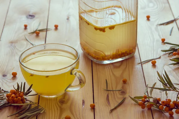 Herbata z rokitnika pomarańczowy jagody w filiżance szkła. — Zdjęcie stockowe