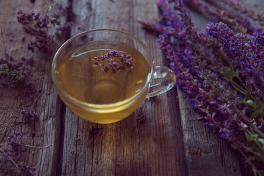 Bitkiler ile yeşil çay. Ahşap adam üzerinde kekik çayı