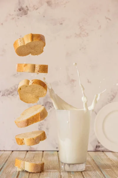 面包和牛奶。飞行的法棍面包和牛奶溅在玻璃 — 图库照片