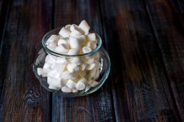 Ahşap bir masa üzerinde bir cam kavanoza marshmallow