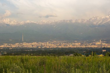 Almatı şehri panoramik manzarası, Kazakistan. Bulutlu gökyüzü, dağlar