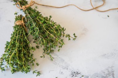 Beyaz zemin üzerine kekik. Bir demet taze kekik