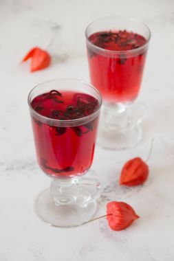 Bir tabloda bir cam bardak kırmızı ebegümeci çayı