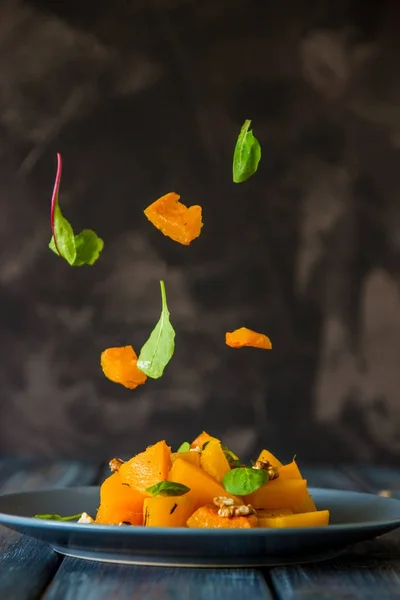 Sallad med pumpa, valnötter och gröna blad, levitation ingre — Stockfoto