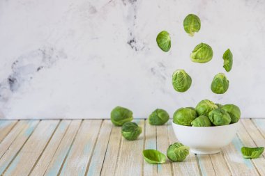 Bir kase içinde uçan Brüksel lahanası. Taze Brüksel lahanası. Lev