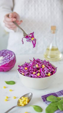 Salata, kırmızı lahana ve Mısır. Kadın eli sala çatalla tutar