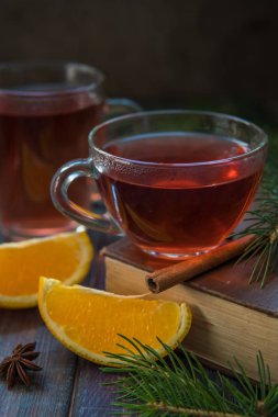 Bir cam kupa, tarçın sopa, portakal ve köknar branc çay