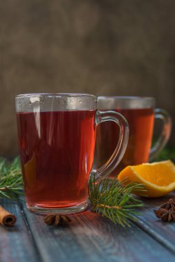 Bir cam kupa, tarçın sopa, portakal ve köknar branc çay