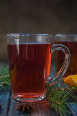 Bir cam kupa, tarçın sopa, portakal ve köknar branc çay