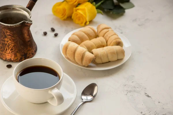 Koffie, jezva en zoete bakkerij op een witte tabel, gele rozen op — Stockfoto