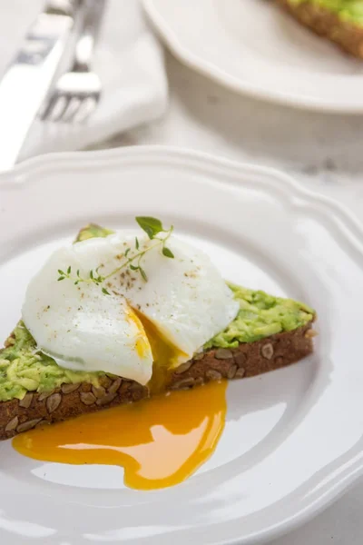 Σάντουιτς με αβοκάντο και αυγό ποσέ. Υγιεινό πρωινό — Φωτογραφία Αρχείου