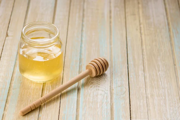 Méz jar, fából készült Stick az asztalra — Stock Fotó