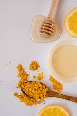 Tatlım sopa, kaşığı zerdeçal ve limon dilimleri ile