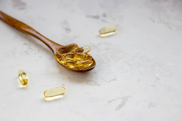 Cápsulas amarillas de vitaminas, cápsula de gelatina blanda con medicamento oleoso y — Foto de Stock