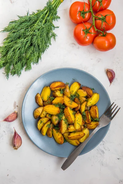 Smažené brambůrky, zelené, rajčata a česnek na stůl — Stock fotografie