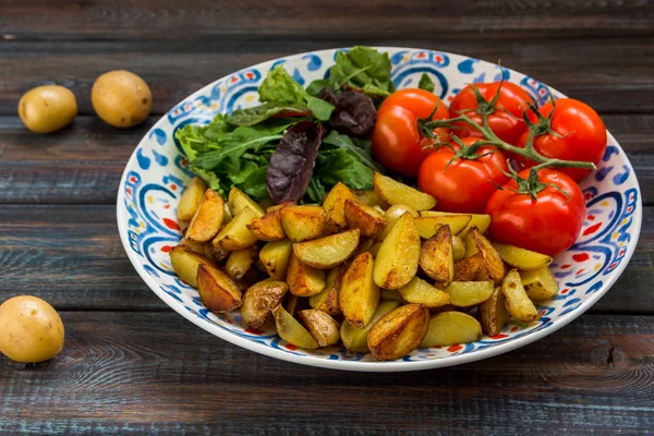 Жареный картофель, зеленый салат и свежие помидоры на большой площади — стоковое фото
