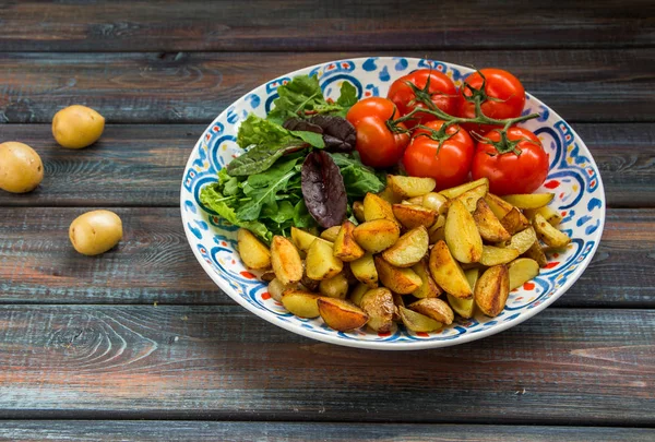 Жареный картофель, зеленый салат и свежие помидоры на большой площади — стоковое фото